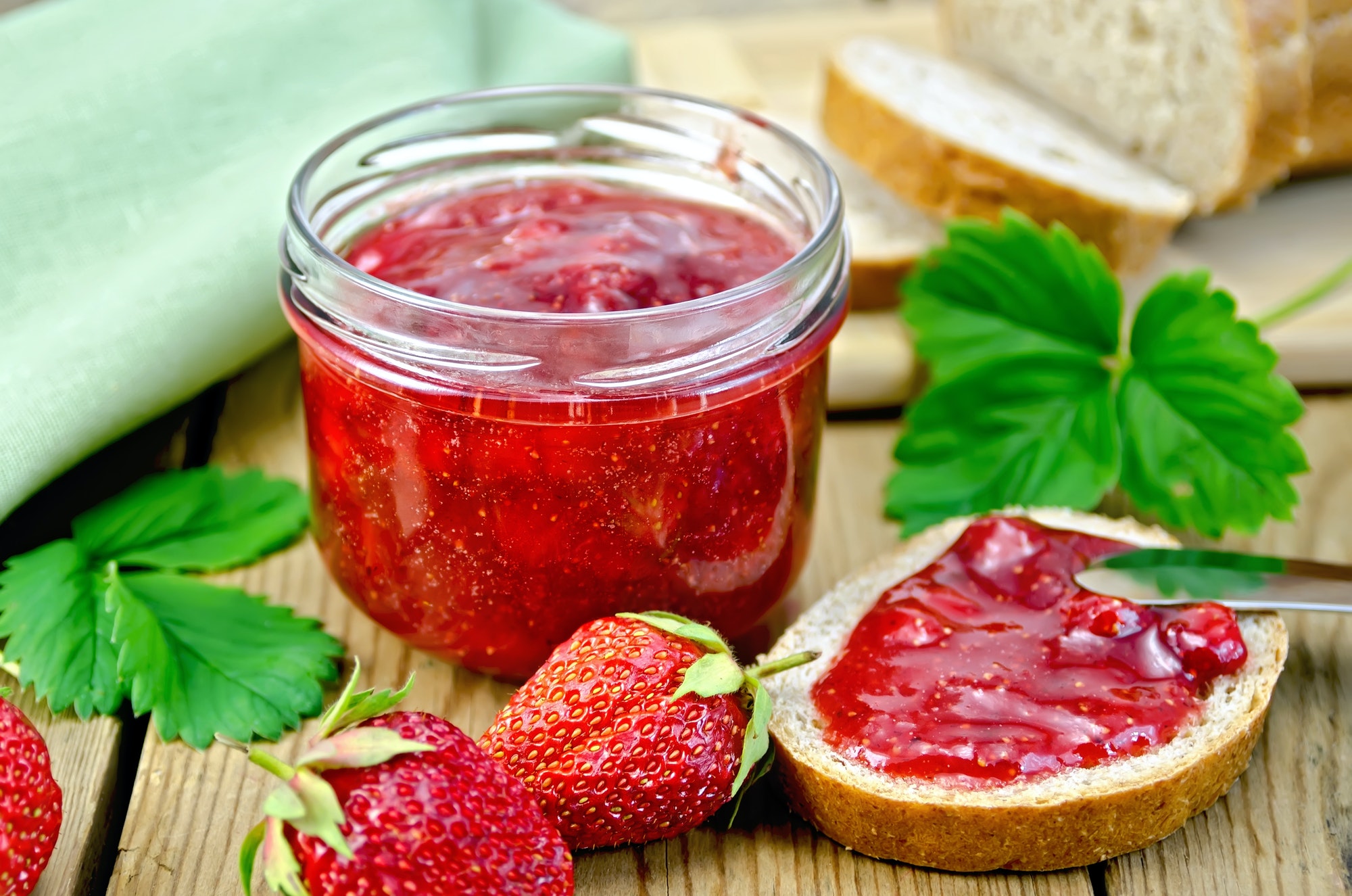 Jam strawberry with bread on the board